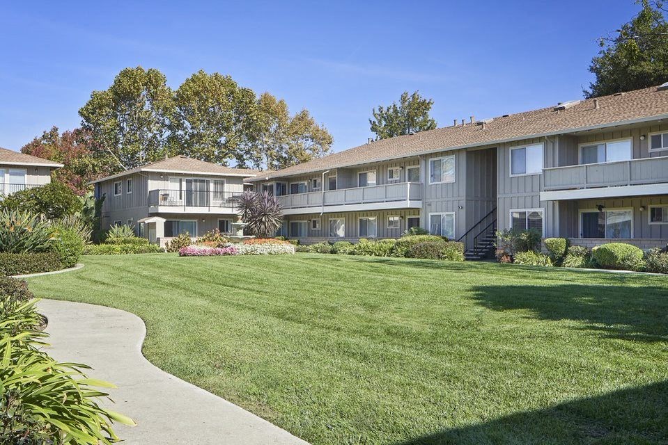 a green lawn in front of some apartments