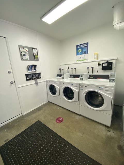 a laundry room with four washing machines in it