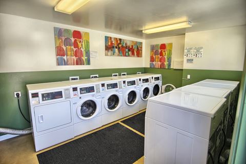 a washer and dryer in a laundry room with a row of washing machines