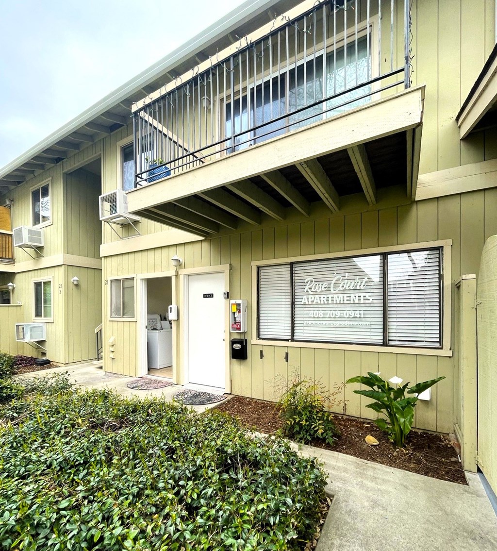 an apartment building with a porch and a sign in the window