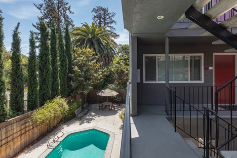 a backyard with a pool and a patio with a table and chairs