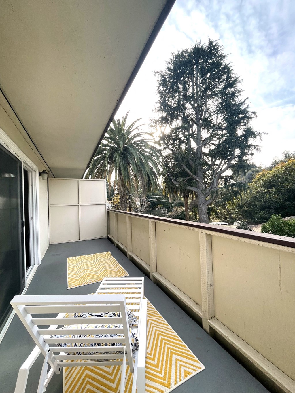 a large balcony with two chairs and a table on it