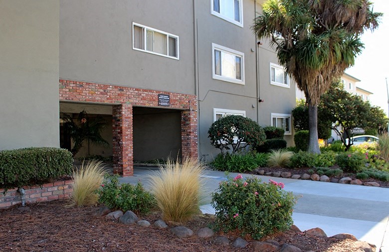 a garage door of an apartment building with palm trees