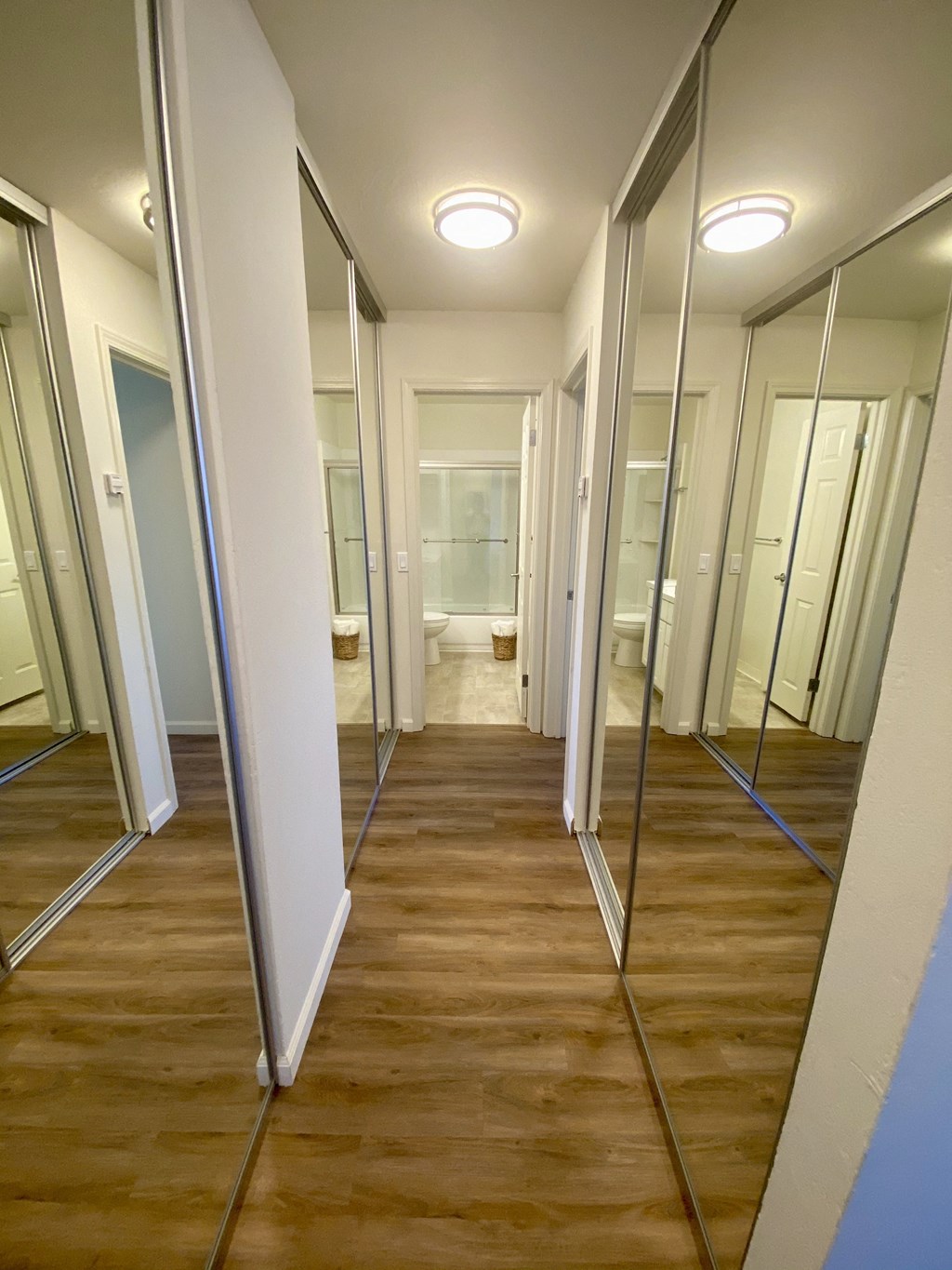 a row of mirrors in a room with a wood floor and mirrors on the wall