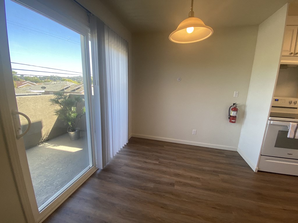 a kitchen with a large window and a door to a balcony