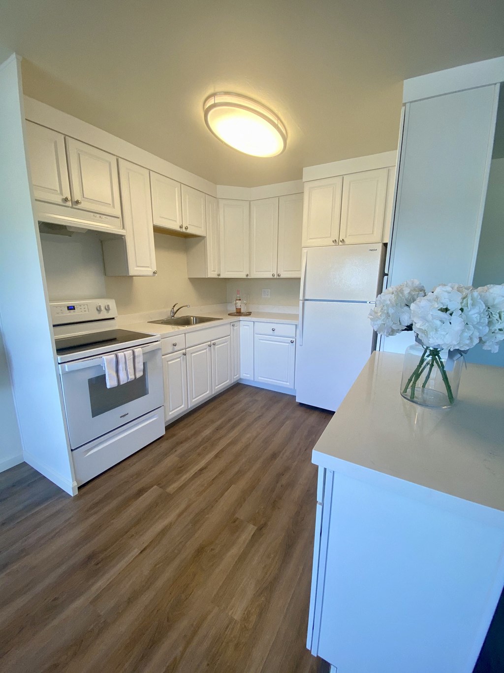 a kitchen with white cabinets and white appliances