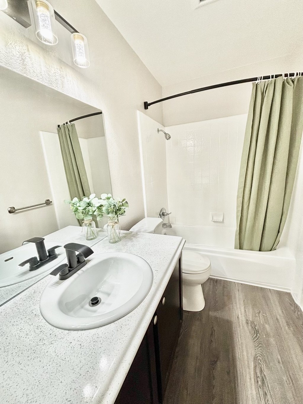 A bathroom with a white countertop and a green shower curtain.