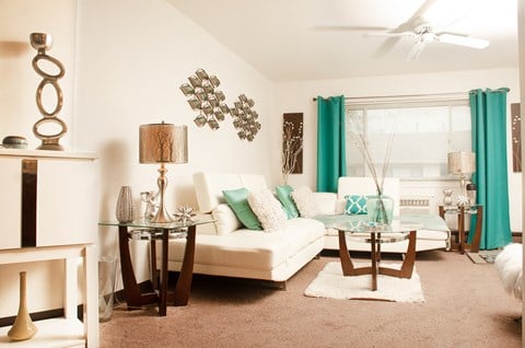 a living room with a white couch and turquoise curtains