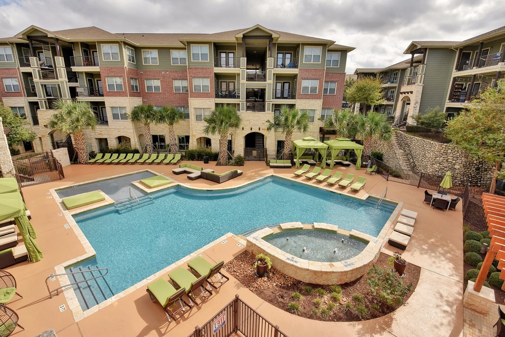 an aerial view of a swimming pool with an apartment building in the background