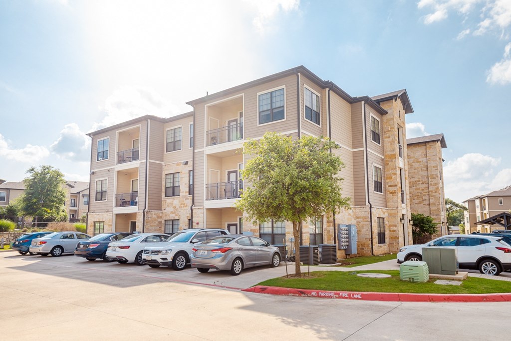 an apartment building with cars parked in front of it