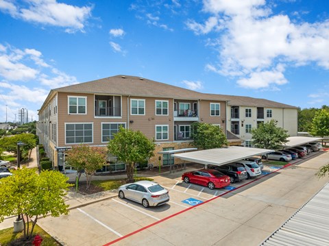 A car is parked in a parking lot in front of a building.
