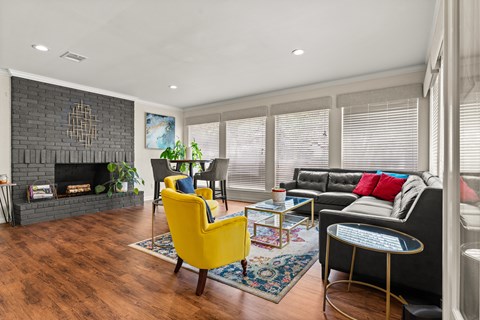 A living room with a yellow chair and a black couch.