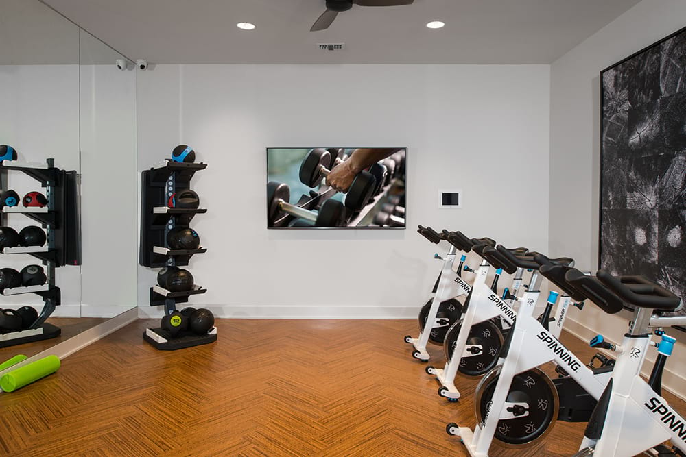 a gym with weights and a tv on the wall