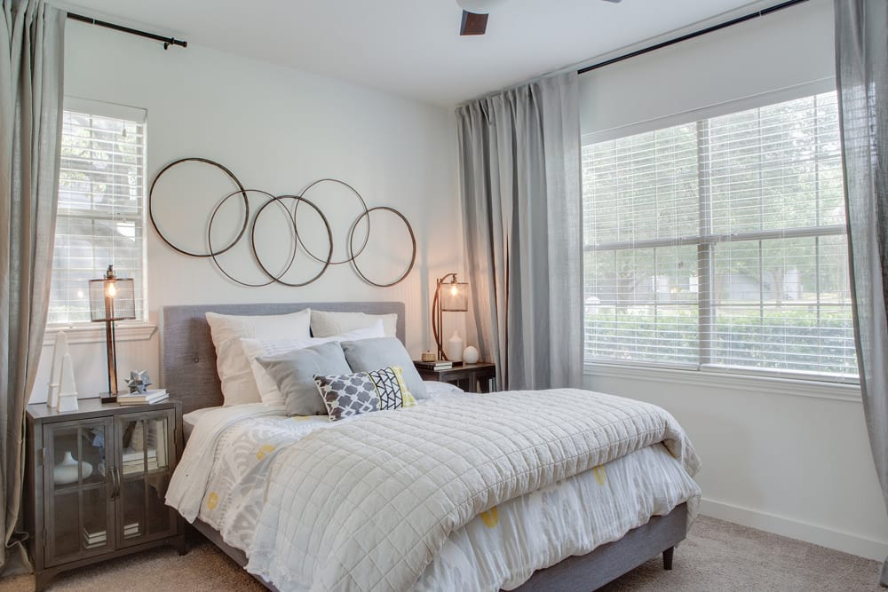 a bedroom with a bed and two windows