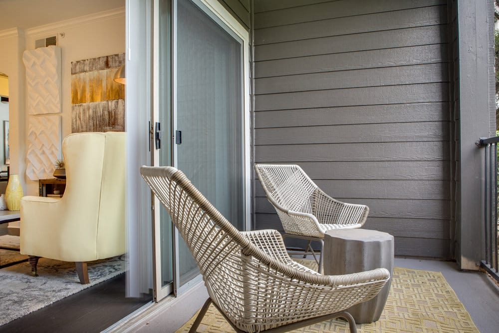 a porch with two chairs and a table and a door