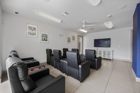 A living room with a black couch and a television.