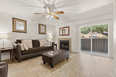 A living room with a brown couch and a fireplace.