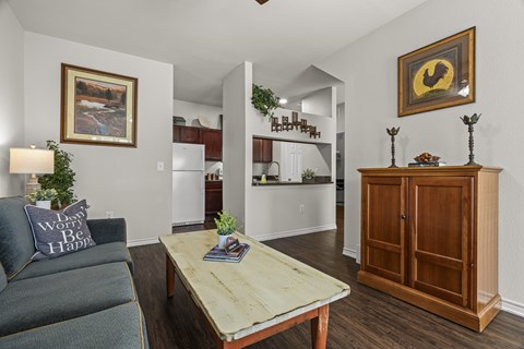 A living room with a grey couch and a wooden coffee table.