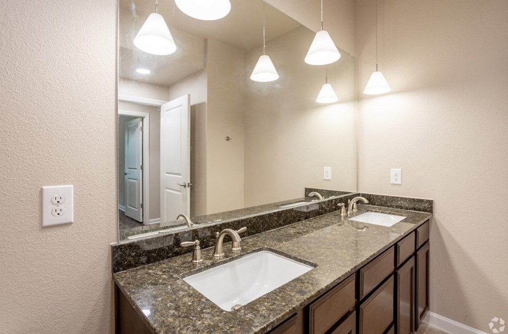 a bathroom with two sinks and a large mirror