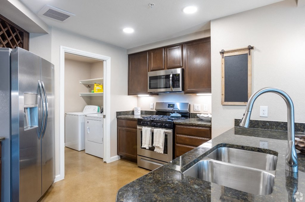 a modern kitchen with stainless steel appliances and granite counter tops