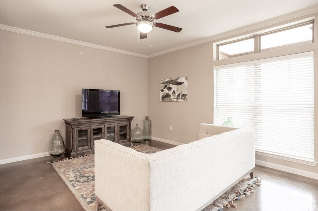 a living room with a couch and a ceiling fan