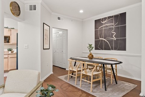 A dining room with a table and chairs.