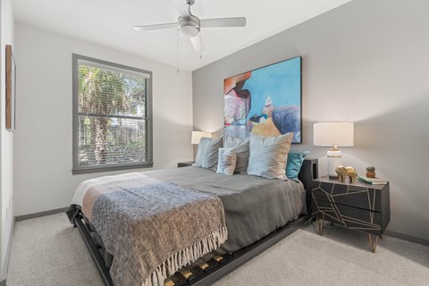 A bedroom with a large bed and a ceiling fan.