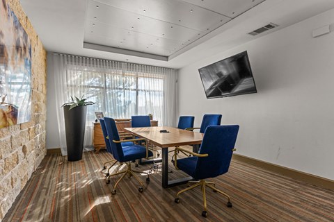 A conference room with a large table and chairs.