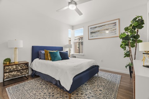 A bedroom with a blue headboard and a white bedspread.