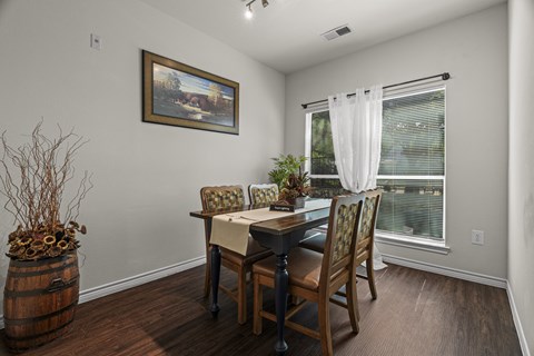 A dining room with a wooden table and chairs.