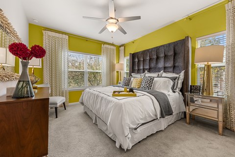 A bedroom with a large bed and a ceiling fan.