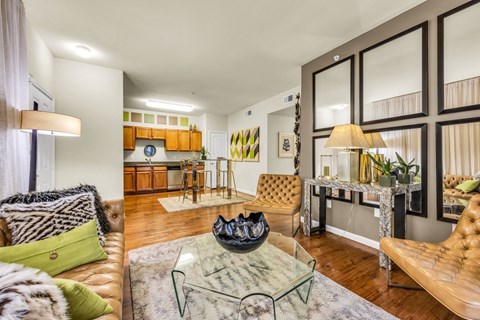 A living room with a brown leather couch and a glass coffee table.