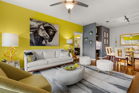 A living room with a white couch and a grey ottoman.