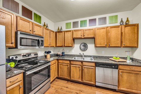 A kitchen with wooden cabinets and stainless steel appliances.