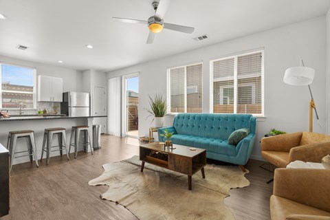 A living room with a blue couch and a wooden coffee table.
