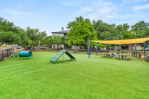 A playground with a green slide and a yellow canopy.