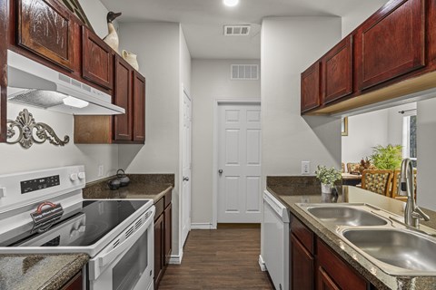 A kitchen with a white stove top oven and a white dishwasher.