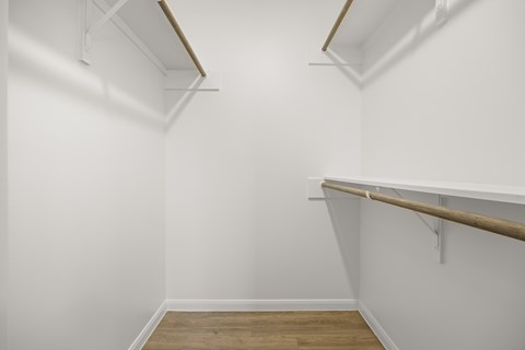 A white room with a wooden floor and a white wall.