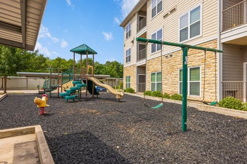 A playground area with a green slide and a yellow fire hydrant.