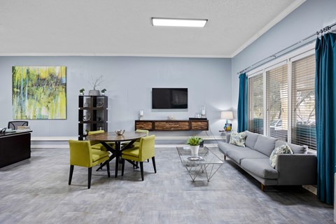 A modern living room with a yellow dining table and grey sofa.