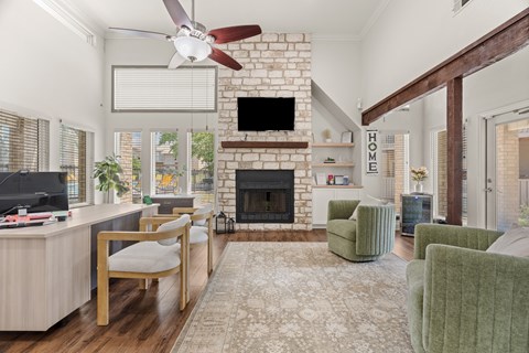 A living room with a fireplace and a TV on the wall.