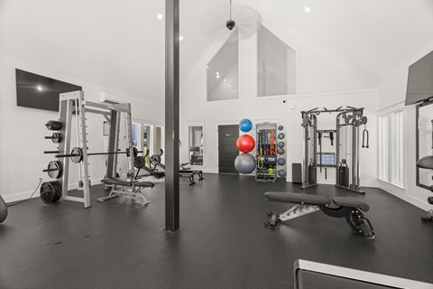 A black and white photo of a gym with a variety of equipment.