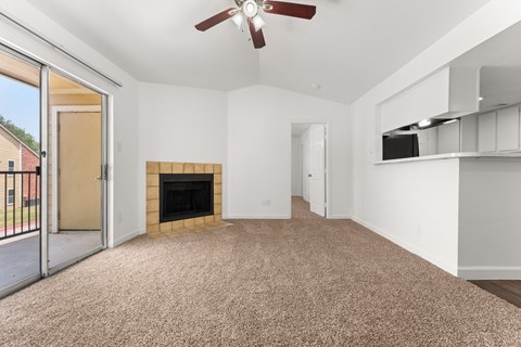 A room with a fireplace and a ceiling fan.