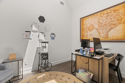A room with a desk, chair, and a map on the wall.