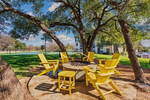 A yellow chair set is placed in a garden.