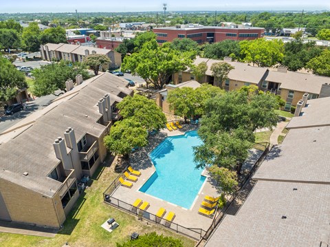 A swimming pool surrounded by trees and buildings.