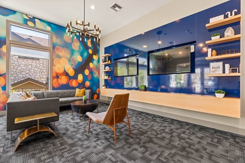 A living room with a grey sofa, a wooden chair and a grey carpet.