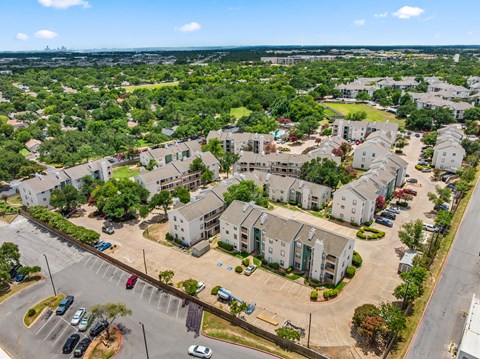 A bird's eye view of a residential area with houses and parked cars.