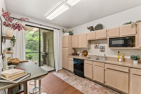 A kitchen with wooden cabinets and a black oven.