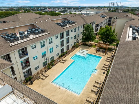An aerial view of a pool surrounded by apartment buildings.